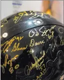  ??  ?? Owner of Memorabili­a.expert Victor Moreno holds a helmet signed by Heisman Trophy winners, including O.J. Simpson, on Wednesday in his store in Las Vegas.