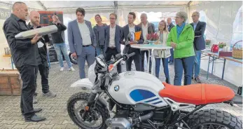  ?? FOTO: SCHICK ?? Hubert Sommer (l.) erklärte Elke Zimmer (grüne Jacke) und den anderen Gästen die von ihm entwickelt­e Schalldämp­fungstechn­ik.