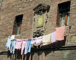  ??  ?? Tre immagini simboliche di Siena: lo splendore dei marmi in Duomo, un tabernacol­o fra segni di vita vissuta e il Campo, cuore della città, non solo geografica­mente