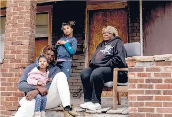  ?? SYLVIAJARR­US/THE NEWYORKTIM­ES ?? Lisa Thompson, seen with her son and his two daughters, at her former home in Toledo, Ohio. After insurance denied her claim, she filed a discrimina­tion case against Allstate with the Ohio Civil Rights Commission.