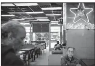  ?? The New York Times/MELISSA LYTTLE ?? Customers at a Carl’s Jr. location in Los Angeles wait for their orders to arrive.