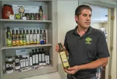  ?? Andrew Rush/Post-Gazette ?? Owner Peter Liokareas displays a bottle of Oilio olive oil at his Liokareas Greek Olive Oil office in Bethel Park.