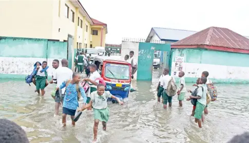  ?? Photo: NAN ?? Pupils of Bayelsa State Model Primary and Secondary School wade through flood water within their school’s premises in Yenagoa yesterday