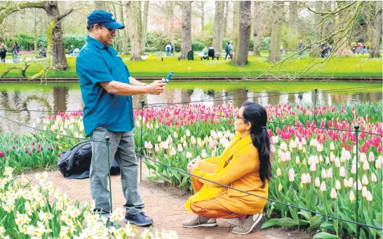  ?? Picture: AFP ?? NOT POPPING THE QUESTION. A couple takes pictures at the Keukenhof gardens in Lisse, western Netherland­s, after the world’s biggest tulip garden opened to the public for its 75th edition. The park, southwest of Amsterdam in the heart of ‘bulb country’, contains millions of tulips of every colour, as well as other flowers across 32 hectares.
