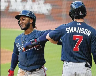  ?? CURTIS COMPTON / CCOMPTON@AJC.COM ?? Ozzie Albies, getting an elbow bump from Dansby Swanson during Monday’s intrasquad game, might have to carry a bigger load for the offense early in the season with Freddie Freeman possibly out.