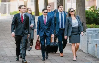  ?? Nathan Howard/Associated Press ?? Justice Department lawyers, including Kenneth Dintzer, center, and Megan Bellshaw, right, arrive Tuesday at the Washington courthouse where they are contending Google has illegally maintained a monopoly in the search industry.