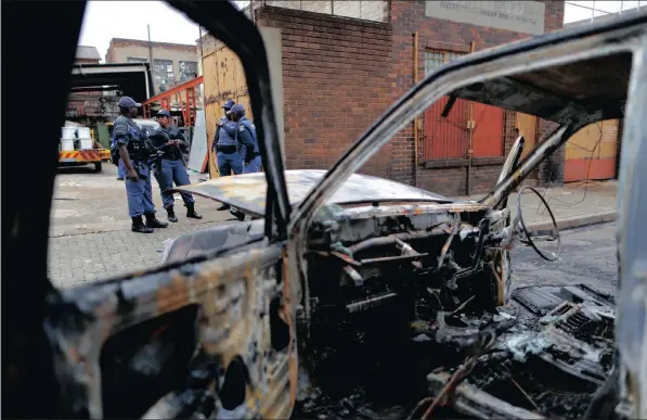  ?? PICTURE: KIM LUDBROOK / EPA ?? Members of the SAPS patrol an area around the Jeppe Street men’s hostel where South African men attacked shops owned by foreign nationals overnight in downtown Joburg recently. Incidents of xenophobic attacks occurred in Pretoria and Joburg at the end...