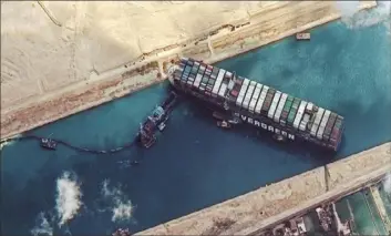  ?? Maxar Technolgie­s via AP ?? A maritime traffic jam grew to more than 200 vessels Friday outside the Suez Canal, and some vessels began changing course as dredgers worked franticall­y to free a giant container ship that is stuck sideways in the waterway and disrupting global shipping.