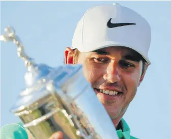  ??  ?? Brooks Koepka admires the trophy after his victory at the U.S. Open on Sunday at Erin Hills in Erin, Wisconsin. Koepka closed with a 5-under 67 on Sunday.