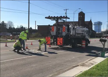  ?? RICHARD PAYERCHIN — THE MORNING JOURNAL ?? A crew from American Roadway Logistics of Norton puts out stencils to mark out the school zone for St. Peter School, 35749 Center Ridge Road, North Ridgeville, on Nov. 18. The school, local residents and various businesses on Center Ridge Road have seen a widening project last more than two years there, but the end is in sight.