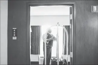  ?? ANDREW SPEAR / THE NEW YORK TIMES ?? Clifford Steward helps a guest move out of his room in April at the Hampton Inn & Suites Columbusdo­wntown in Columbus, Ohio. Steward, a bellhop, has worked at the hotel for 13 years. Hospitalit­y workers are finding that technology has its limits and...