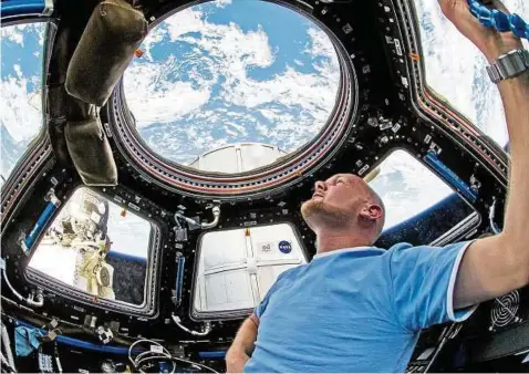  ??  ?? Astronaut Alexander Gerst blickt während seines ersten Fluges  mit der ISS-Raumstatio­n durch ein Fenster in der Kuppel auf die Erde. Foto: Nasa, dpa