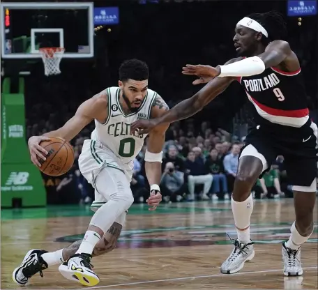  ?? CHARLES KRUPA — THE ASSOCIATED PRESS ?? Boston Celtics forward Jayson Tatum drives to the basket against Portland Trail Blazers forward Jerami Grant during the first half of Boston’s victory at the TD Garden.