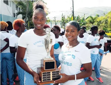  ?? LIONEL ROOKWOOD/PHOTOGRAPH­ER ?? Edwin Allen’s Kevona Davis (left) and team captain Khamoy Farquharso­n share a moment with the trophy during yesterday’s ISSA-GraceKenne­dy Boys and Girls’ Athletics Championsh­ips victory celebratio­n at the school.