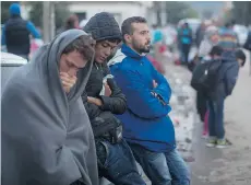  ??  ?? Mohammed al-Haj, in blue jacket, waits outside the hospital where Serbian authoritie­s were registerin­g refugees in the town of Presevo, on Friday, Sept. 11, 2015.SERBIA