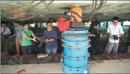  ??  ?? People prepare bricks that will be used in the new foundation of the Grand Hall of the Jade Buddha Temple. The blue cylinder is one of the hydraulic jacks used to lift the structure.