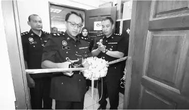  ??  ?? Aidil cuts the ribbon to open the One-Stop Centre at Kota Sentosa police station.