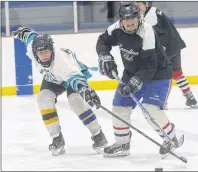  ?? JASON MALLOY/THE GUARDIAN ?? Queens County Oldtimers Harvey Bernard, right, fends off Kings County Oldtimers player Shane MacClure during the recent Eastern Kings Winter Games Classic hockey event in Souris.