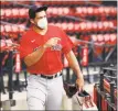  ?? Elise Amendola / Associated Press ?? Red Sox pitcher Nathan Eovaldi walks through the seating area to the field for training camp at Fenway Park on Monday.