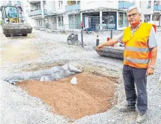  ?? FOTO: HERFURTH ?? Projektlei­ter Manfred Feyrer zeigt auf die Mitte des künftigen Kreisverke­hrs. Dort soll später ein Baum gepflanzt werden.