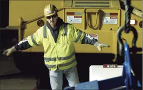  ?? Christian Abraham / Hearst Connecticu­t Media file photo ?? A file photo of an O&G Industries worker positionin­g a roadway divider in Trumbull. O&G was among the early adopters of a system created by Triax Technologi­es to keep tabs of workers on constructi­on job sites. In 2020, the Norwalk startup re-engineered the system to signal if workers violate six feet of distance and keep a log for contact tracing.