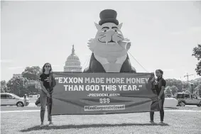  ?? Joy Asico/associated Press ?? Activists protest record profits by Exxon and other oil majors in front of the U.S. Capitol on July 13. The top 28 publicly traded independen­t oil producers generated $25.5 billion in free cash flow in the second quarter of 2022.