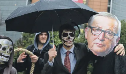  ??  ?? A demonstrat­or with a mask of European Commission President Jean-Claude Juncker, right, and another with facepaint pose in front of EU headquarte­rs to highlight the glyphosate issue in front of EU headquarte­rs in Brussels last Monday