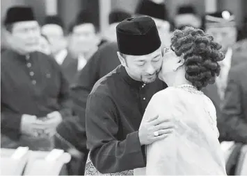  ??  ?? THANKS MOM: Mukhriz hugs his mother after the ceremony. — Bernama photo