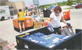  ??  ?? Volunteers unload thousands of boxes of non-perishable goods donated at the WFCU Centre on Saturday.