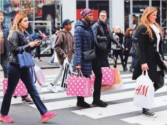  ?? GETTY IMAGES ?? People shop in New York City on Black Friday. Retailers are trying to entice the nation’s 75 million millennial­s, who are putting their own distinctiv­e stamp on the holiday retail experience.