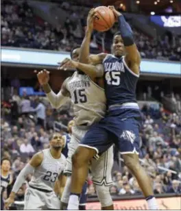  ?? NICK WASS — THE ASSOCIATED PRESS ?? Villanova forward Darryl Reynolds (45) grabs a rebound against Georgetown center Jessie Govan (15) during the first half Saturday in Washington. Reynolds came into the game once it was clear Govan might be able to control the glass.