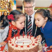  ??  ?? I want a really big slice please, with cherries: Labour finance spokesman David Parker celebrates KiwiSaver’s 5th birthday last year at the Cook Island Childcare Centre in Wellington with Tara Williams and Taelyn McLean-Vea.