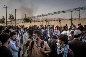  ?? Jim Huylebroek/The New York Times ?? People hoping to gain access gather outside the internatio­nal airport Wednesday in Kabul, Afghanista­n. With days remaining until a withdrawal deadline, thousands of U.S. citizens and tens of thousands of Afghans who qualify for special immigratio­n visas are waiting for evacuation.