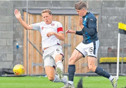  ?? Picture: SNS Group. ?? Going places: Kevin Nisbet battles Hearts’ Christophe Berra for the ball.