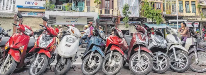  ?? FOTOS: DPA ?? Rent a bike? In Saigon ist das nur eingeschrä­nkt zu empfehlen – der Verkehr ist recht chaotisch.