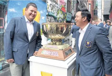  ?? AFP ?? Thai players Prom Meesawat, left, and Kiradech Aphibarnra­t pose with the World Cup of Golf trophy in Melbourne.