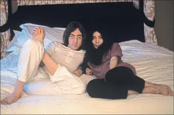  ??  ?? John and Yoko pose together on a bed, their signature setting for photos, in 1968