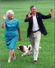  ?? SCOTT APPLEWHITE — THE ASSOCIATED PRESS FILE ?? President George H.W. Bush and first lady Barbara Bush walk with their dog Millie across the South Lawn as they return to the White House. Bush has died at age 94. Family spokesman Jim McGrath says Bush died shortly after 10 p.m. Friday about eight months after the death of his wife, Barbara Bush.