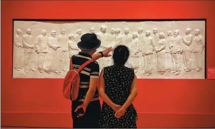  ?? JIANG DONG / CHINA DAILY Togetherne­ss, at the National Art ?? Two visitors look at Discussing­StateAffai­rs, a relief sculpture by Wu Weishan on show at the ongoing exhibition, Museum of China in Beijing, which runs through Sunday.