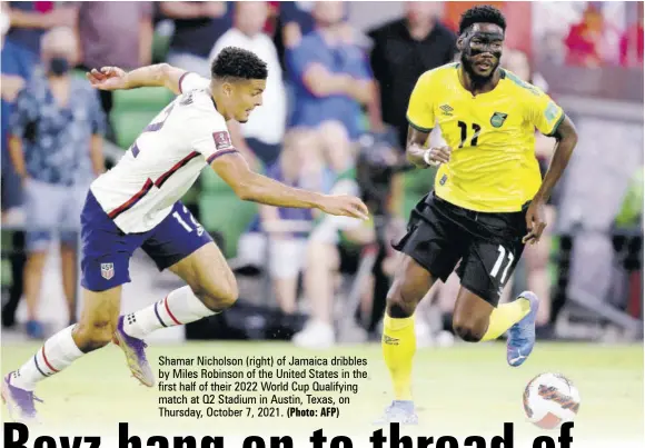  ?? (Photo: AFP) ?? Shamar Nicholson (right) of Jamaica dribbles by Miles Robinson of the United States in the first half of their 2022 World Cup Qualifying match at Q2 Stadium in Austin, Texas, on Thursday, October 7, 2021.