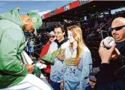  ?? Miranda Alam/Special to The Chronicle ?? A's reliever Domingo Acevedo signs autographs for Ty Bennett (center) and Karmela Jasic on Saturday.