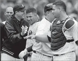  ?? KATHY WILLENS/AP PHOTO ?? Yankees manager Aaron Boone, left, congratula­tes Gleyber Torres, second from left, after Torres hit a walk-off, three-run homer in the ninth inning of Sunday’s game against the Indians at New York.