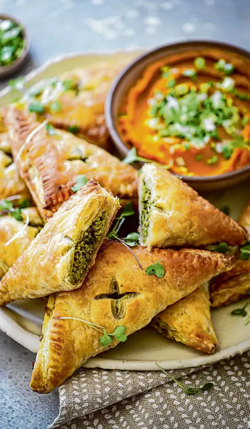  ?? Amisha Gurbani/Special to the Chronicle ?? These crisp, buttery pastries are filled with green garlic, peas and spices.