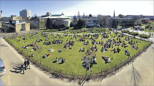  ??  ?? Students relaxing in the glorious sunshine on the grass near Dundee University. Sadly the unseasonal temperatur­es are forecast to be replaced by chillier conditions.