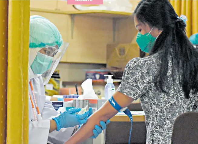  ?? AFP ?? • Una mujer se somete a una vacunación con una dosis experiment­al contra el nuevo coronaviru­s en Indonesia.