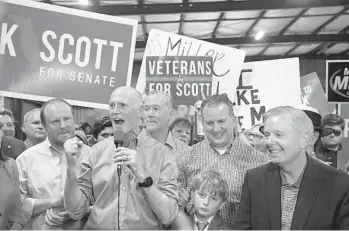  ?? PHELAN M. EBENHACK/FOR THE ORLANDO SENTINEL ?? Florida Gov. Rick Scott addresses supporters in Orlando during a rally for his U.S. Senate bid as U.S. Sen. Lindsey Graham, R-S.C., right, listens in November.