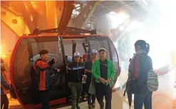  ??  ?? Tourists disembarki­ng from a cable car at the station near the top of Fansipan Mountain in the northern Sapa tourist town.