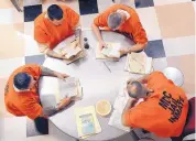  ?? JIM THOMPSON/ JOURNAL ?? Inmates at the Metropolit­an Detention Center take part in a book club in January 2012.