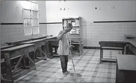  ?? AP/JEROME DELAY ?? A cleaner in Kinshasa, Congo, prepares a school classroom Saturday to become a polling station for today’s presidenti­al elections.