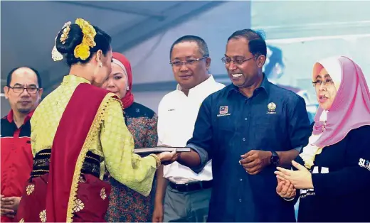  ??  ?? By the book: Zambry, at the launching of the SL1M Open Interview Programme at Universiti Sultan Idris (UPSI) in Tanjung Malim, being presented with a copy of ‘Faith’ from a UPSI student in traditiona­l Perak attire. Looking on are (from left) UPSI Vice-...